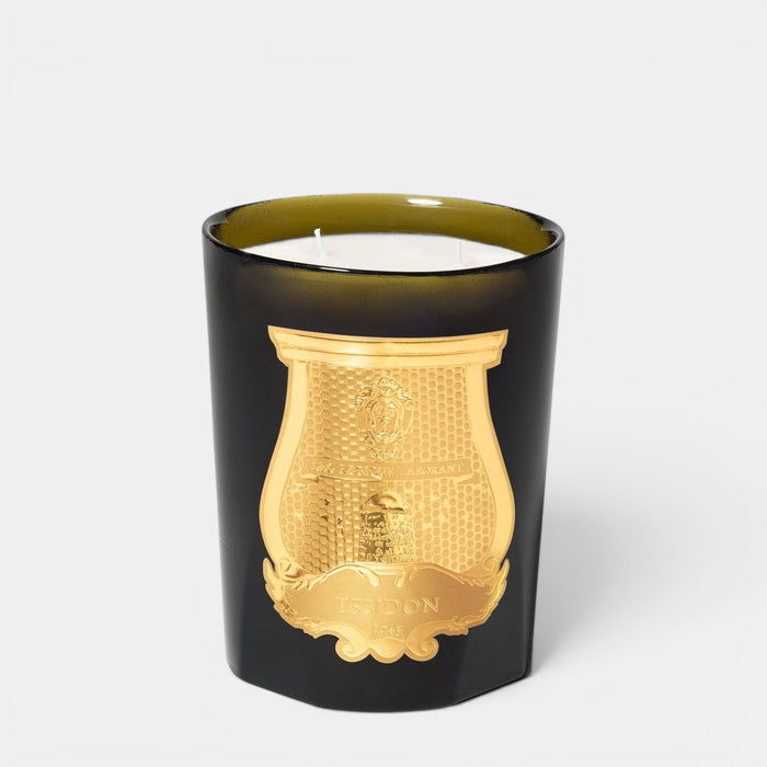 Black candle with gold emblem on a white background