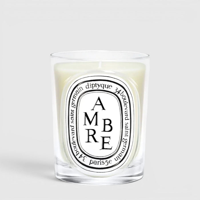 Shop Rescue Spa Diptyque Ambre scented candle in a clear glass vessel with a signature oval label