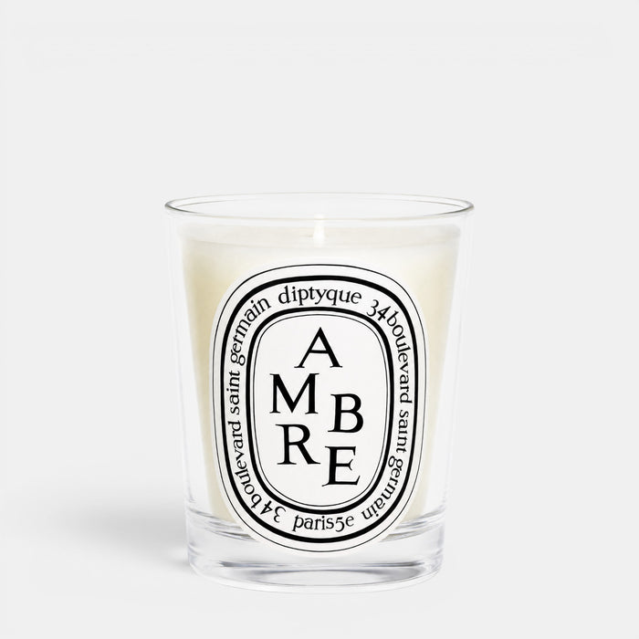 Shop Rescue Spa Ambre woody scented candle in a clear glass jar with a signature oval label