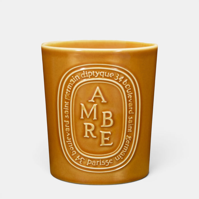 Shop Rescue Spa Ambre woody scented candle in a warm amber-colored ceramic vessel with embossed branding.