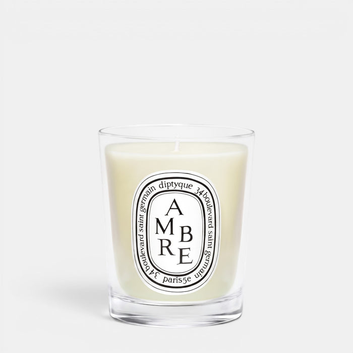 Shop Rescue Spa Ambre scented candle in a clear glass jar with a signature oval white label and woody fragrance.
