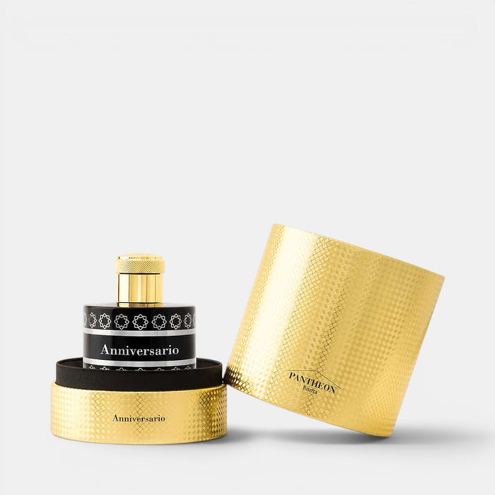 Pantheon Paris Anniversary perfume bottle with a textured gold cap and base, a black band with silver detailing, and its matching textured gold cylindrical box on a white background.