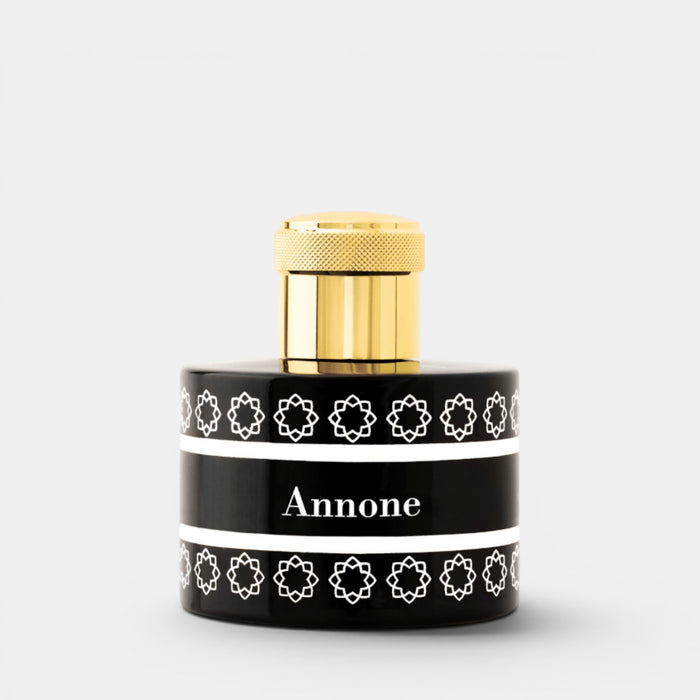 A cylindrical perfume bottle with a glossy black body, a textured gold cap, and a black label featuring white geometric patterns and the name 'Annone' in white text, set against a light gray background.