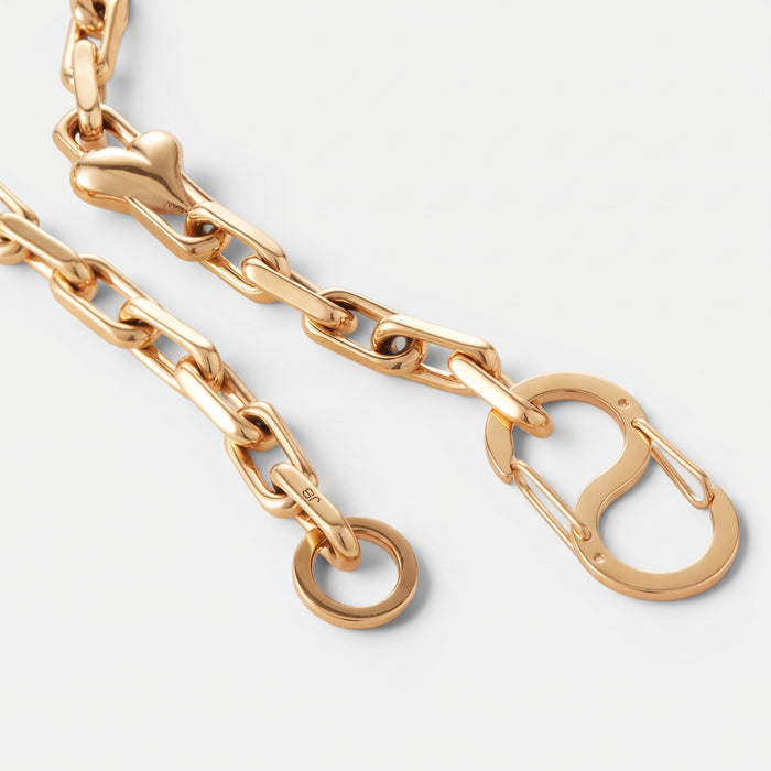 Shop Rescue Spa gold chain necklace featuring faceted links, voluminous heart charms, and an exaggerated S-clasp.