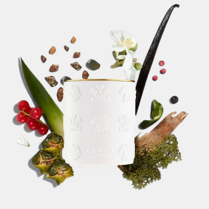 Shop Rescue Spa Aventus candle in a white porcelain jar with gold rim, surrounded by bergamot, pineapple, and oakmoss.