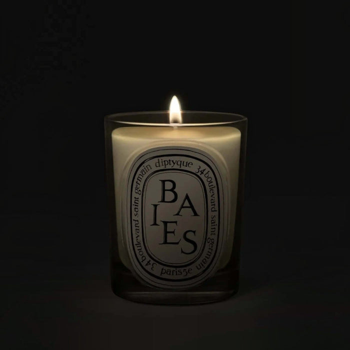 Shop Rescue Spa Baies candle in a glass vessel with a glowing flame against a dark background
