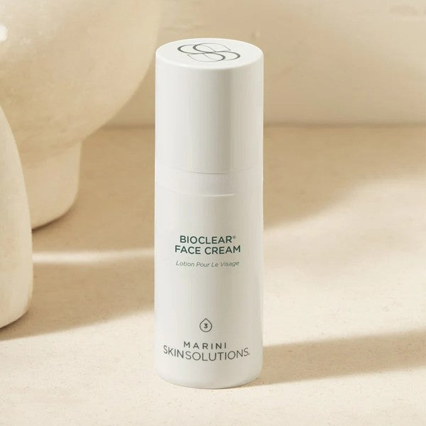 Green bottle of Bioclear Face Cream by Jan Marini on a beige background