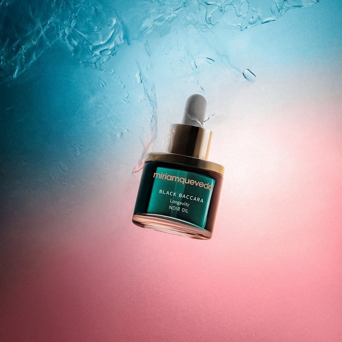 Shop Rescue Spa Black Baccara Longevity Noir Oil in a glass dropper bottle floating in water with blue and pink light