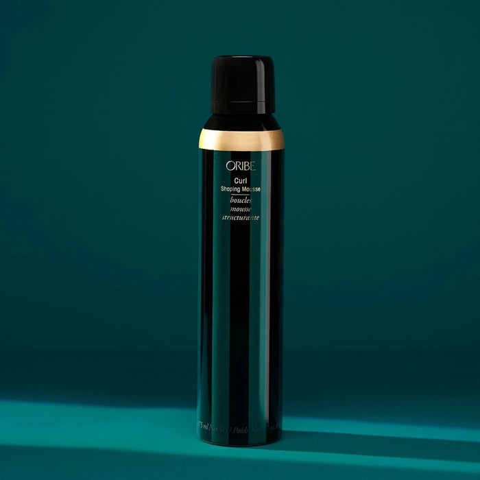 Shop Rescue Spa Oribe Curl Shaping Mousse in a dark green bottle with gold accent, for defining curls and preventing frizz.