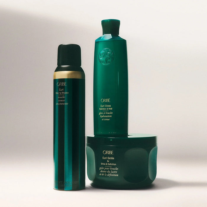 Shop Rescue Spa ORIBE Curl Shaping Mousse in a dark teal can with gold accents, defining curls without stiffness.