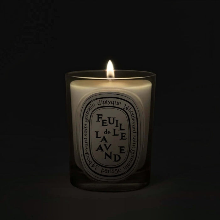 Shop Rescue Spa Feuille De Lavende scented candle in a clear glass vessel with a glowing flame against a dark background