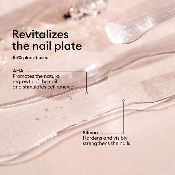 Close-up of a clear nail treatment gel swirled on pale pink nail plate with text reading 'Revitalizes the nail plate', '85% plant-based', 'AHA Promotes the natural regrowth of the nail and stimulates cell renewal', and 'Silicon Hardens and visibly strengthens the nails'.