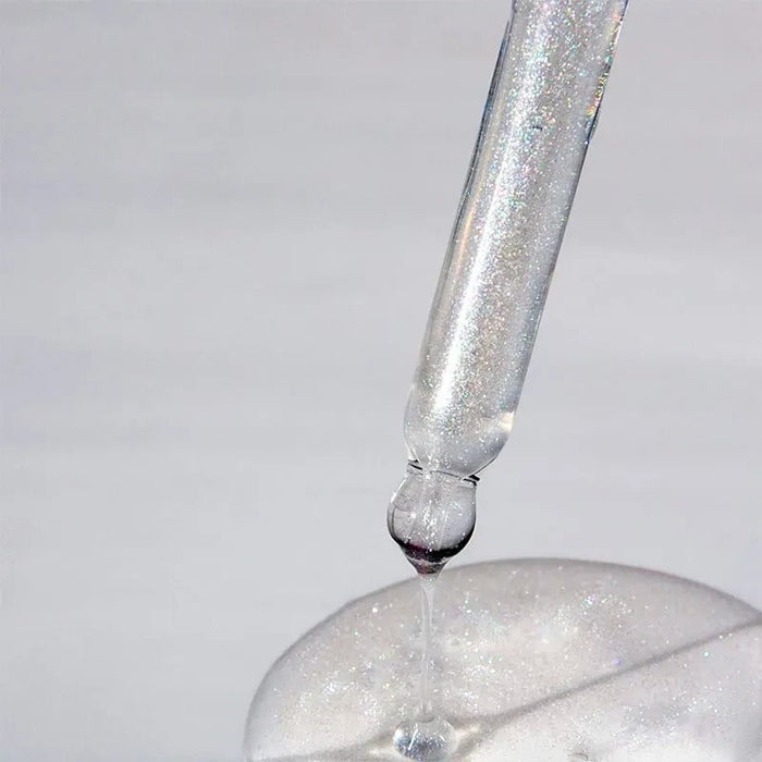 Shop Rescue Spa Glacial White Caviar Hydra-Pure Precious Elixir shimmering hair oil dripping from a glass dropper