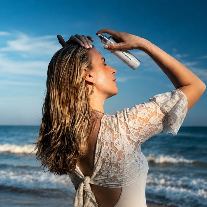 Shop Rescue Spa Glacial White Caviar Hydra-Pure Rejuvenating Mist applied by a woman on a sunny beach