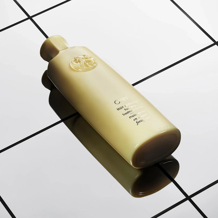 Shop Rescue Spa Oribe Hair Alchemy Fortifying Treatment Serum bottle on a reflective black and white tiled surface.