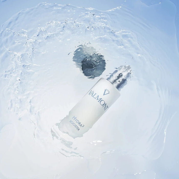 Shop Rescue Spa Valmont Hydra3 Booster serum bottle submerged in clear water with a refreshing splash effect