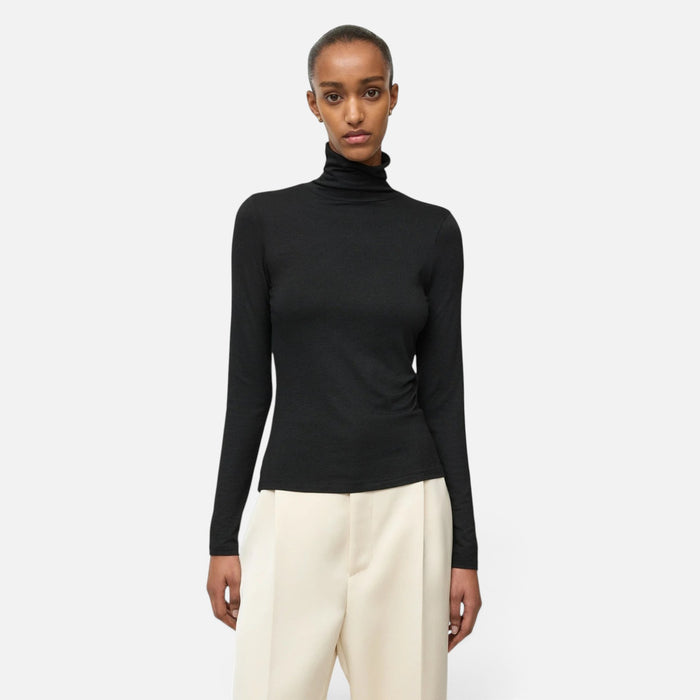 Shop Rescue Spa lightweight black jersey turtleneck made from a Tencel and cashmere blend worn by a model