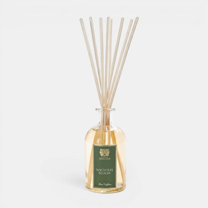 Antica Magnolia Bloom reed diffuser with wooden sticks in a glass bottle on a white background