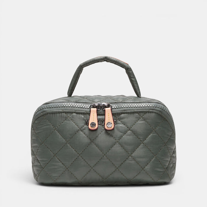 A dark gray quilted cosmetic bag with a top handle, featuring two rose gold zipper pulls with crystal accents, set against a light gray background.