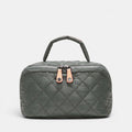 A dark gray quilted cosmetic bag with a top handle, featuring two rose gold zipper pulls with crystal accents, set against a light gray background.