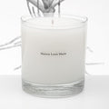 White candle in a glass jar with 'Maison Louis Marie' branding on a white background