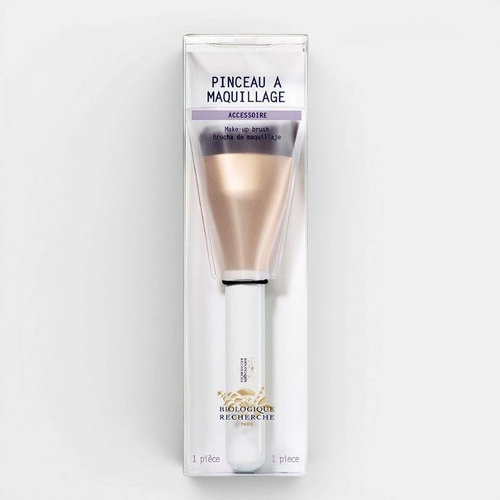 Makeup brush in packaging with visible brand name on a white background