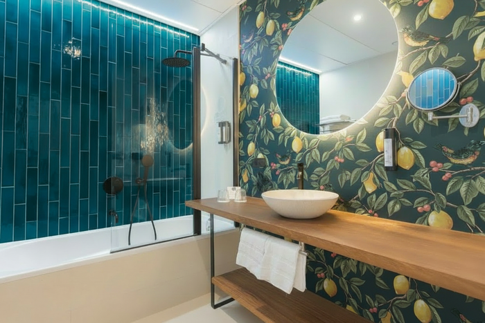 Bathroom with Ponderosa wallpaper floor to ceiling, under bench detail, and darker teal tiles