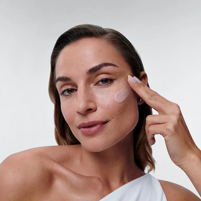 Shop Rescue Spa Restorative Skin Complex peptide serum applied to a woman's cheek for anti-aging and skin brightening