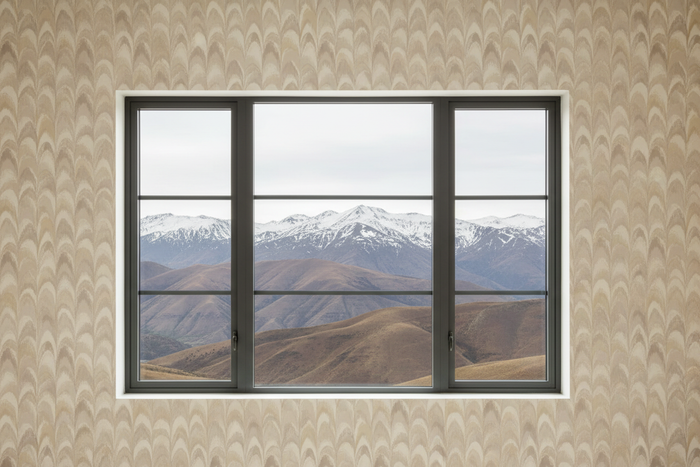 Peacock feather wallpaper in cream with modern window and mountain view