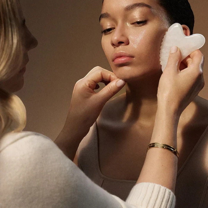 Shop Rescue Spa Danucera Sculpting Stone made of white jade being used for a facial massage on a model