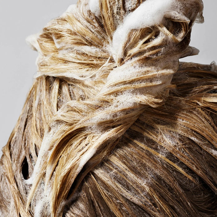 Shop Rescue Spa Oribe Shampoo for Magnificent Volume lathered into blonde hair to create thick and full texture
