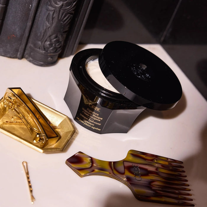Shop Rescue Spa Oribe Signature Moisture Masque, a rich, deep-hydrating hair masque in a black jar with a gold label.