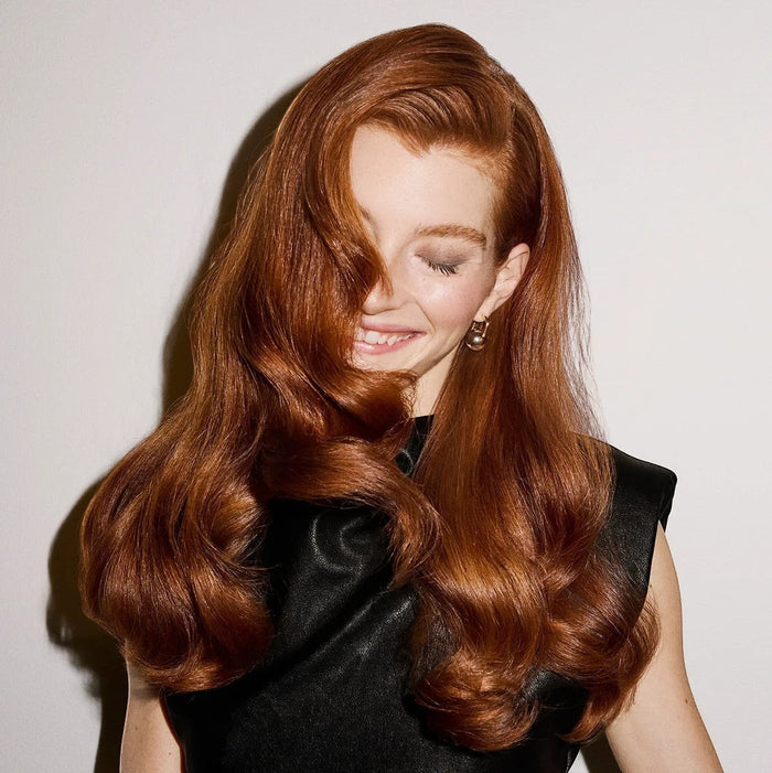Shop Rescue Spa Supershine Moisturizing Cream used by a woman with long, shiny, wavy red hair.