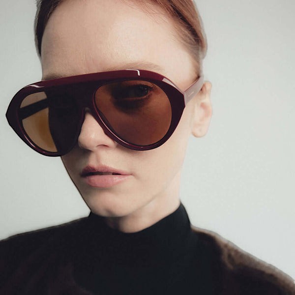 Model wearing Past Midnight The Icon Sunglasses in burgundy, showing fit and frame shape.