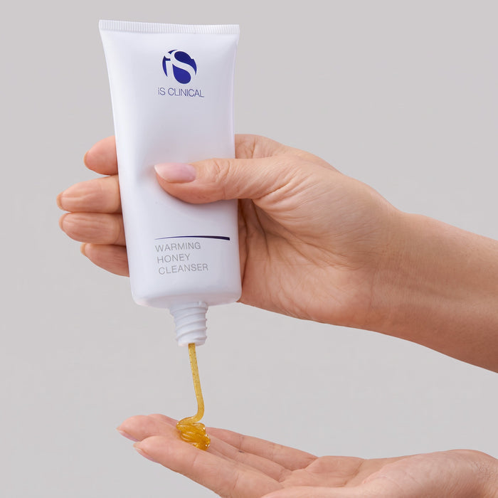 Shop Rescue Spa iS Clinical Warming Honey Cleanser gel being squeezed from a white tube onto a palm