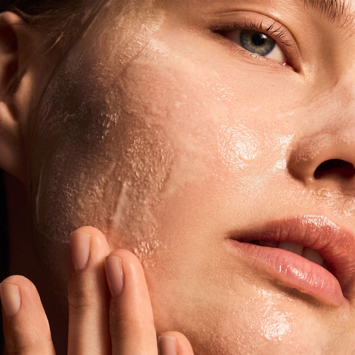 Shop Rescue Spa Warming Honey Cleanser applied as a rich, golden gel texture on a woman's face for deep cleansing.